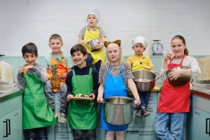 Sieben Kinder kochen in der Küche
